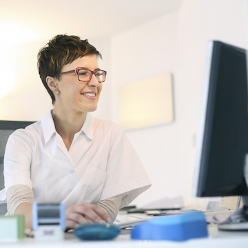 woman doctor working at computer smiling